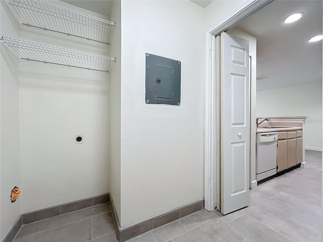 laundry area with electric dryer hookup, electric panel, and sink