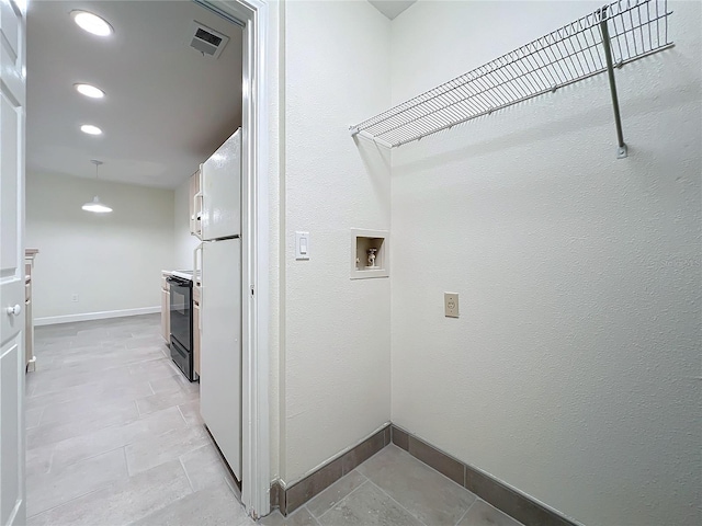 laundry room featuring light tile patterned flooring and washer hookup