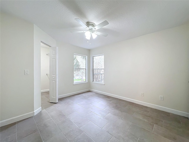 unfurnished room featuring ceiling fan and a textured ceiling