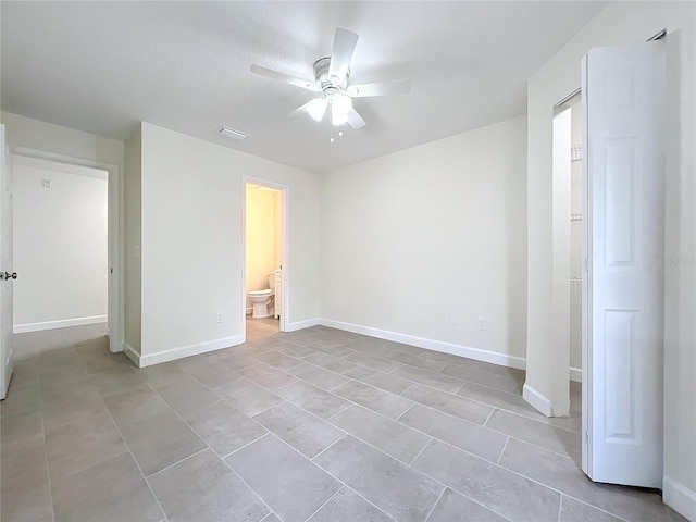 unfurnished bedroom featuring ceiling fan and ensuite bath