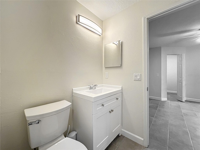 bathroom featuring vanity, a textured ceiling, toilet, and ceiling fan