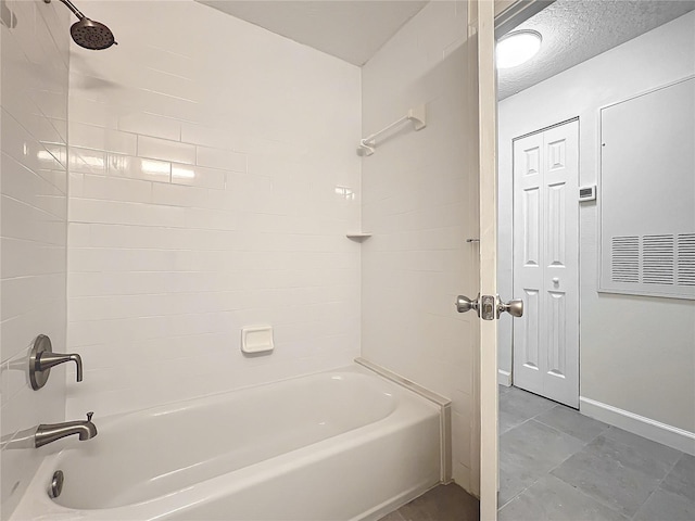 bathroom with tile patterned flooring and washtub / shower combination