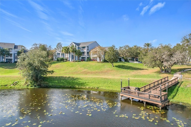 dock area with a lawn and a water view