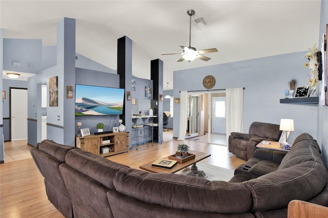 living room with ceiling fan, high vaulted ceiling, and light wood-type flooring