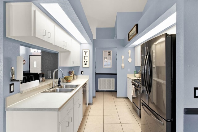 kitchen with white cabinetry, sink, light tile patterned floors, and black appliances