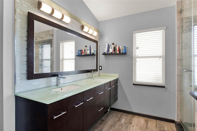 bathroom with hardwood / wood-style floors, tasteful backsplash, lofted ceiling, vanity, and walk in shower