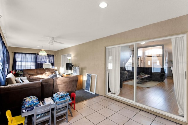 tiled living room with plenty of natural light and ceiling fan