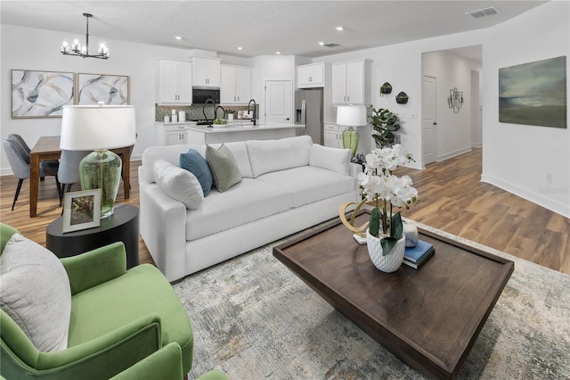 living room with hardwood / wood-style flooring and a notable chandelier