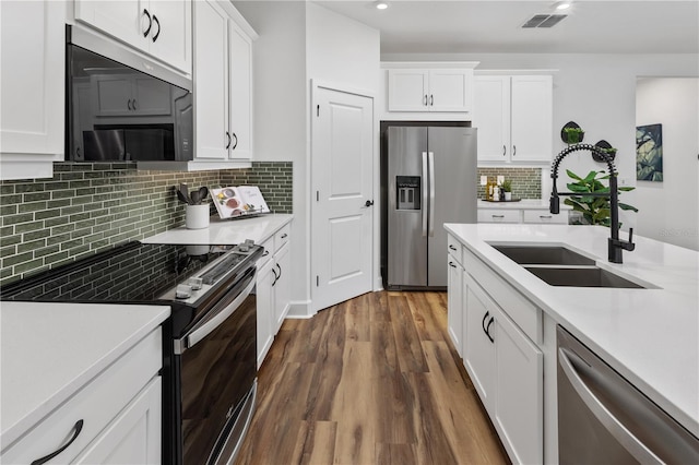 kitchen with white cabinets, dark hardwood / wood-style flooring, stainless steel appliances, and sink