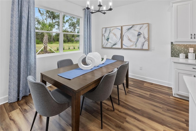 dining space with dark hardwood / wood-style flooring and a notable chandelier