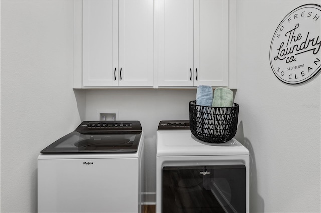 laundry room featuring washing machine and clothes dryer and cabinets