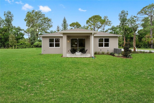 rear view of property featuring a yard and cooling unit