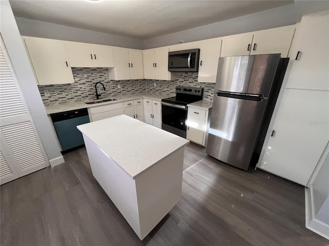 kitchen with dark hardwood / wood-style flooring, stainless steel appliances, sink, white cabinets, and a kitchen island