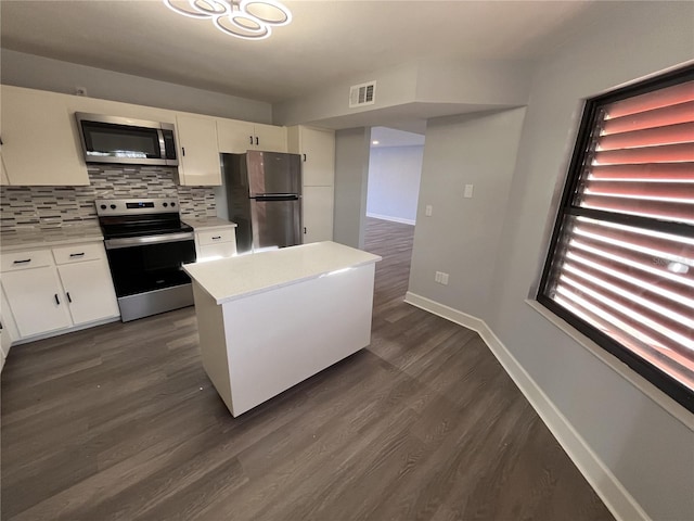 kitchen featuring decorative backsplash, dark hardwood / wood-style flooring, white cabinets, and stainless steel appliances