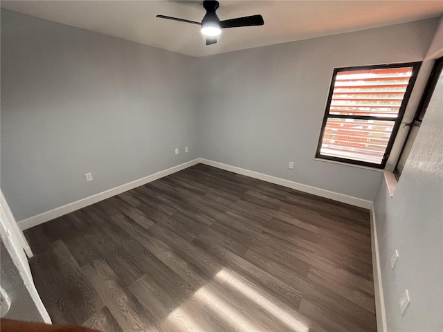 empty room with dark hardwood / wood-style flooring and ceiling fan