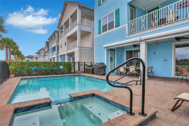 view of pool with an in ground hot tub, a patio, ceiling fan, and grilling area