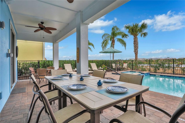 view of patio with ceiling fan and a swimming pool with hot tub