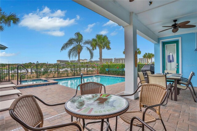 view of swimming pool with ceiling fan, an in ground hot tub, and a patio