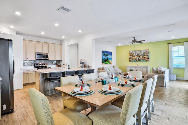 dining area with ceiling fan and light hardwood / wood-style floors