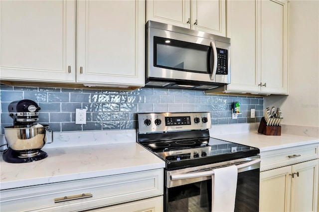 kitchen with appliances with stainless steel finishes, tasteful backsplash, and light stone counters