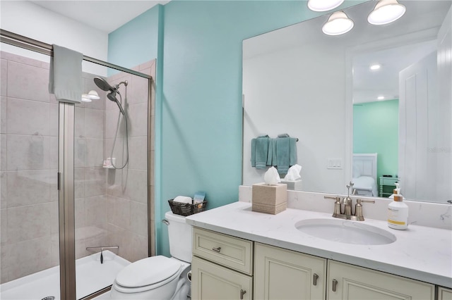 bathroom with vanity, toilet, and a shower with shower door