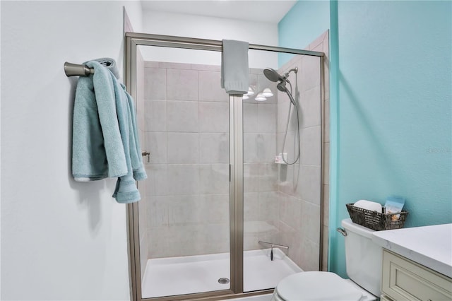 bathroom with toilet, an enclosed shower, and vanity