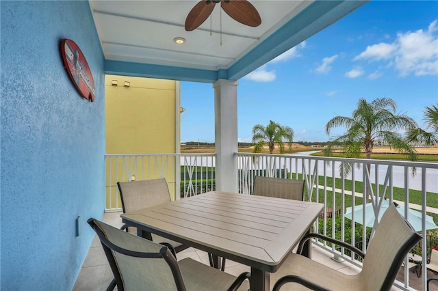 balcony with ceiling fan and a water view