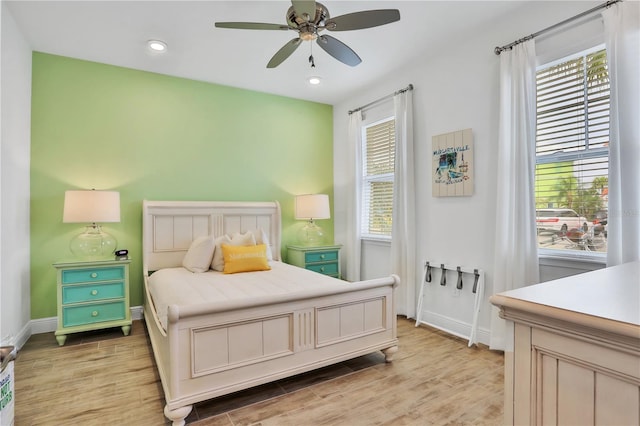 bedroom featuring multiple windows, ceiling fan, and light hardwood / wood-style floors