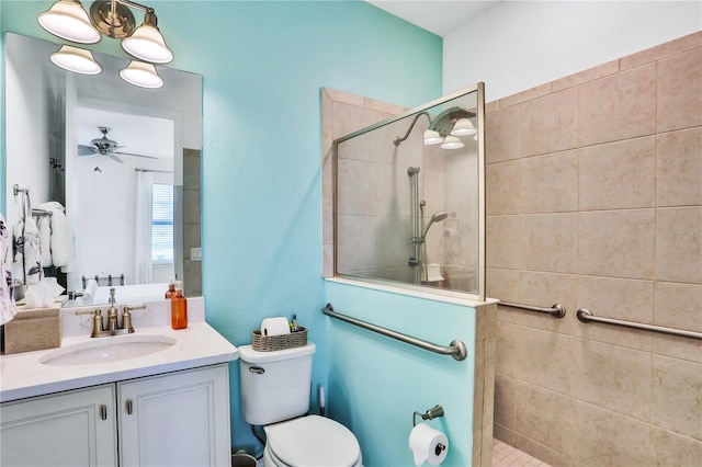 bathroom featuring a tile shower, vanity, toilet, and ceiling fan