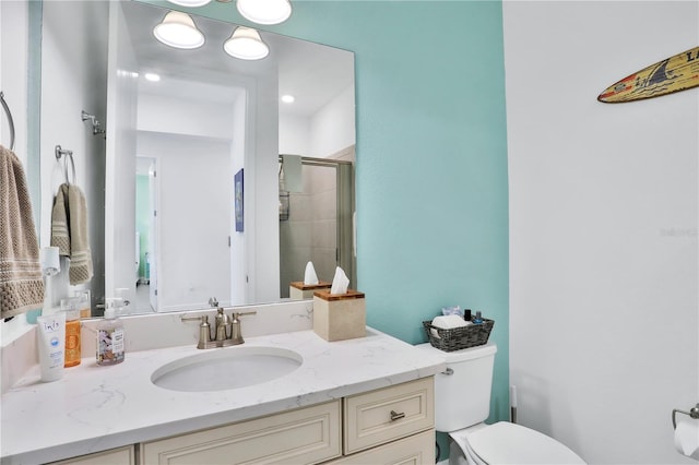 bathroom featuring vanity, toilet, and a shower with door