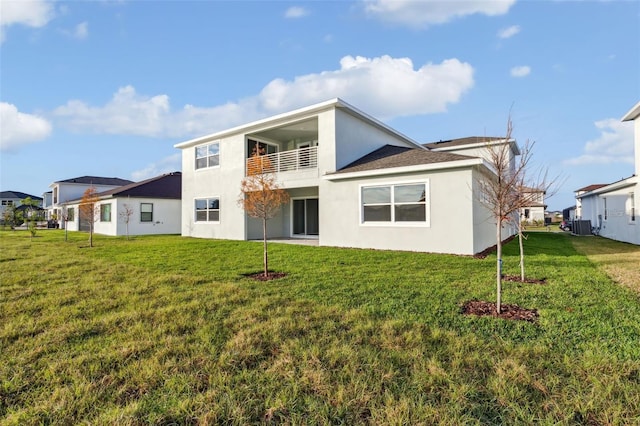 back of house featuring a yard, a balcony, and central air condition unit