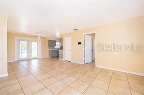 tiled spare room featuring french doors