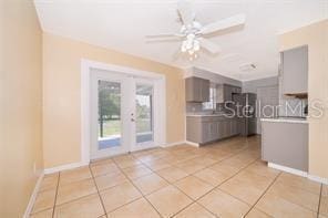 unfurnished living room with ceiling fan and light tile patterned floors