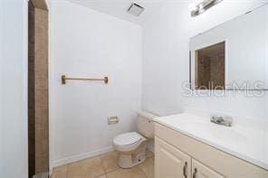 bathroom with tile patterned flooring, vanity, and toilet