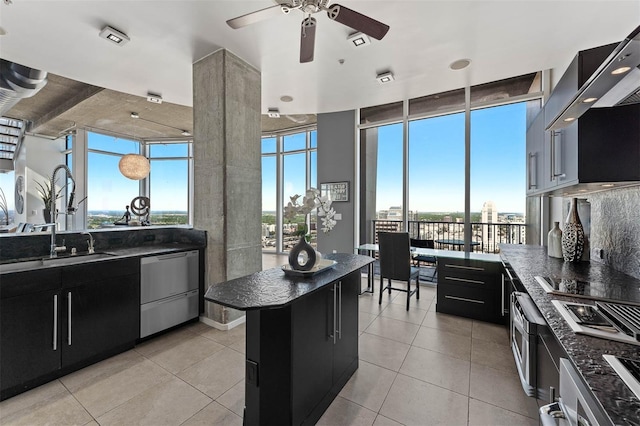 kitchen featuring light tile patterned flooring, ventilation hood, stainless steel dishwasher, ceiling fan, and a kitchen island