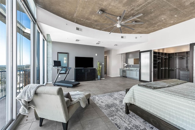 bedroom featuring ceiling fan, expansive windows, access to outside, and a closet