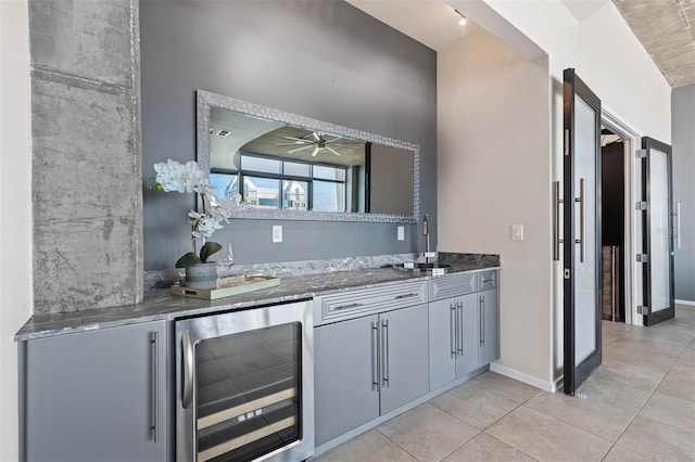 bar featuring sink, wine cooler, ceiling fan, gray cabinets, and light tile patterned floors