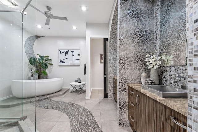 bathroom featuring vanity, tile patterned floors, ceiling fan, tile walls, and a tub