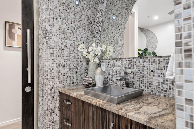 bathroom featuring vanity and tasteful backsplash