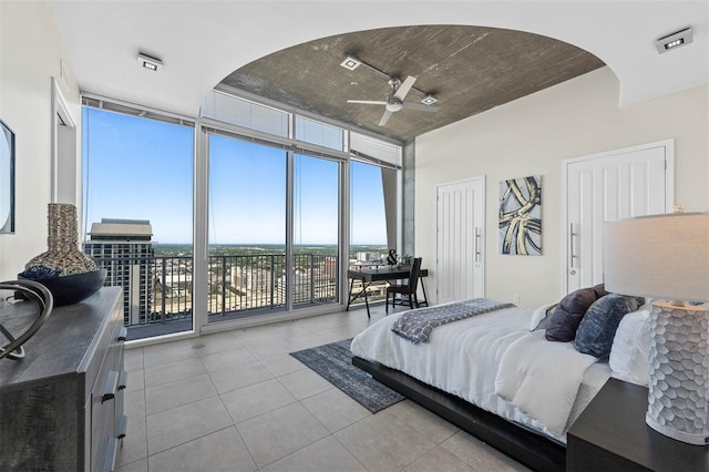 bedroom featuring access to exterior, ceiling fan, a closet, and expansive windows