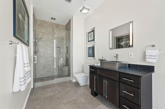 bathroom with tile patterned floors, vanity, tiled shower, and toilet