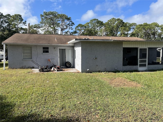 rear view of house with a lawn and a sunroom