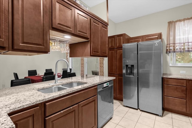 kitchen with light stone counters, sink, light tile patterned floors, and appliances with stainless steel finishes