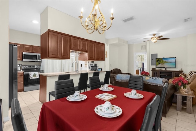 tiled dining room with ceiling fan with notable chandelier and sink