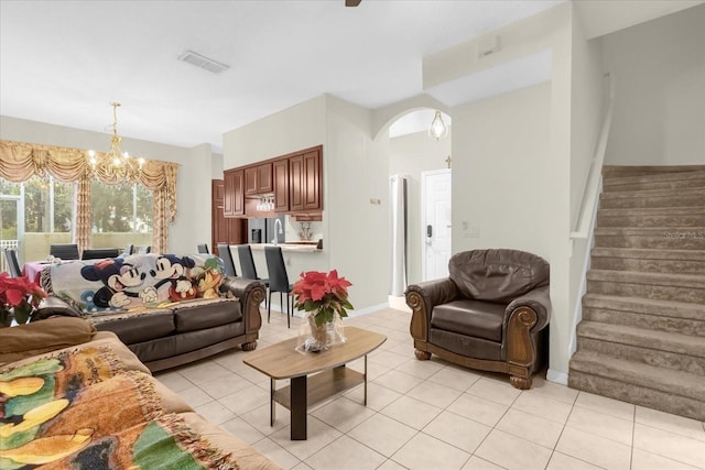 tiled living room with a notable chandelier