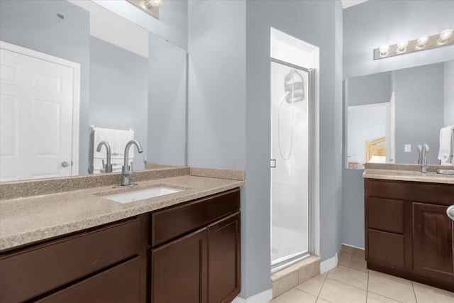 bathroom with tile patterned floors, a shower with door, and vanity