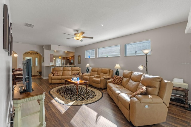 living room with dark hardwood / wood-style floors, ceiling fan, and a textured ceiling