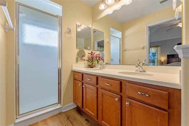 bathroom with hardwood / wood-style floors, vanity, ceiling fan, and walk in shower