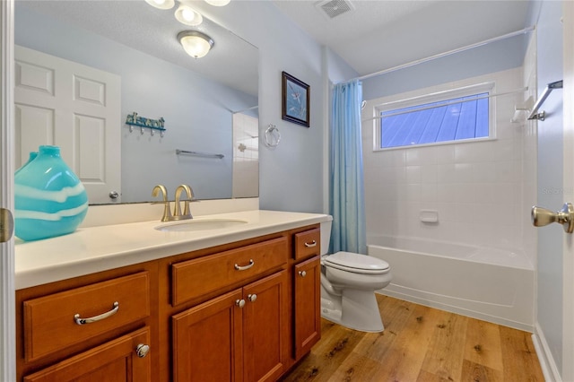 full bathroom with hardwood / wood-style floors, vanity, toilet, and shower / bath combo with shower curtain