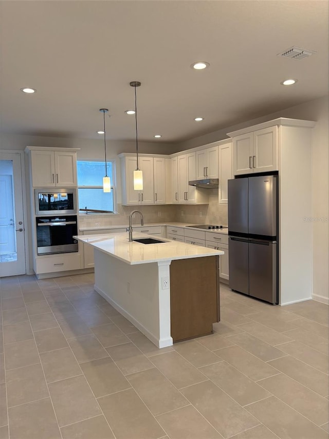 kitchen featuring white cabinets, sink, light tile patterned floors, decorative light fixtures, and stainless steel appliances